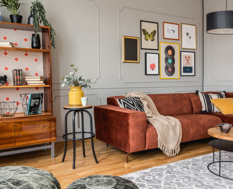 Vintage black poufs in trendy eclectic living room interior with brown couch